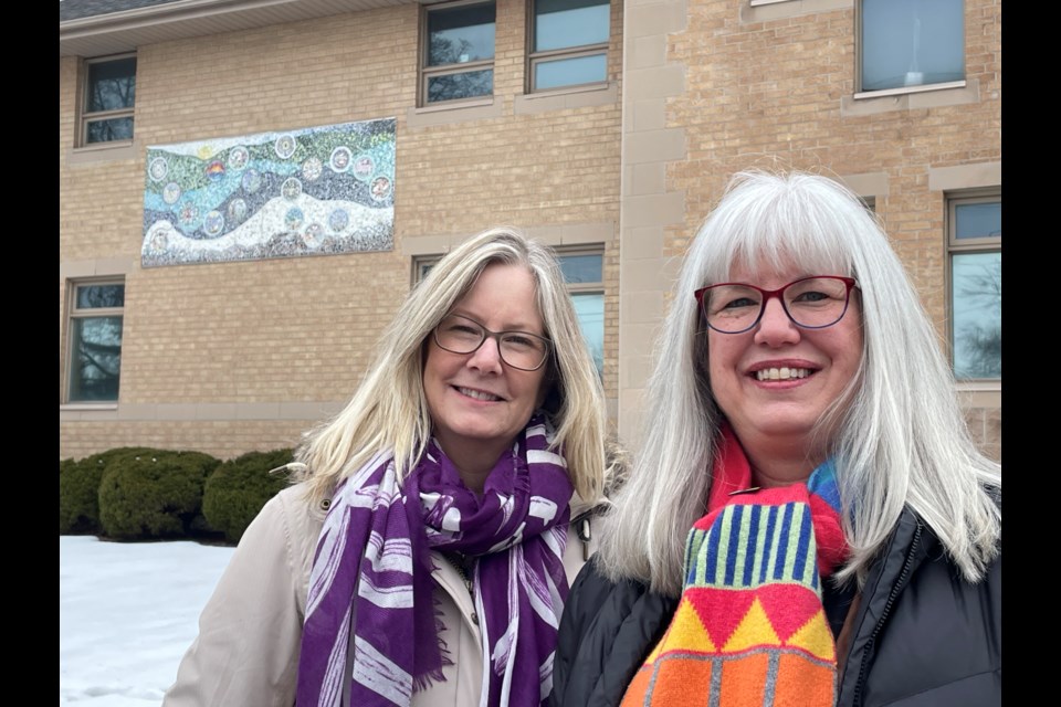 Workshop leader and artist Mary Abma, right, and Women's Interval Home Executive Director Jennifer Vansteenkiste, with the new mosaic on the south side of the building.