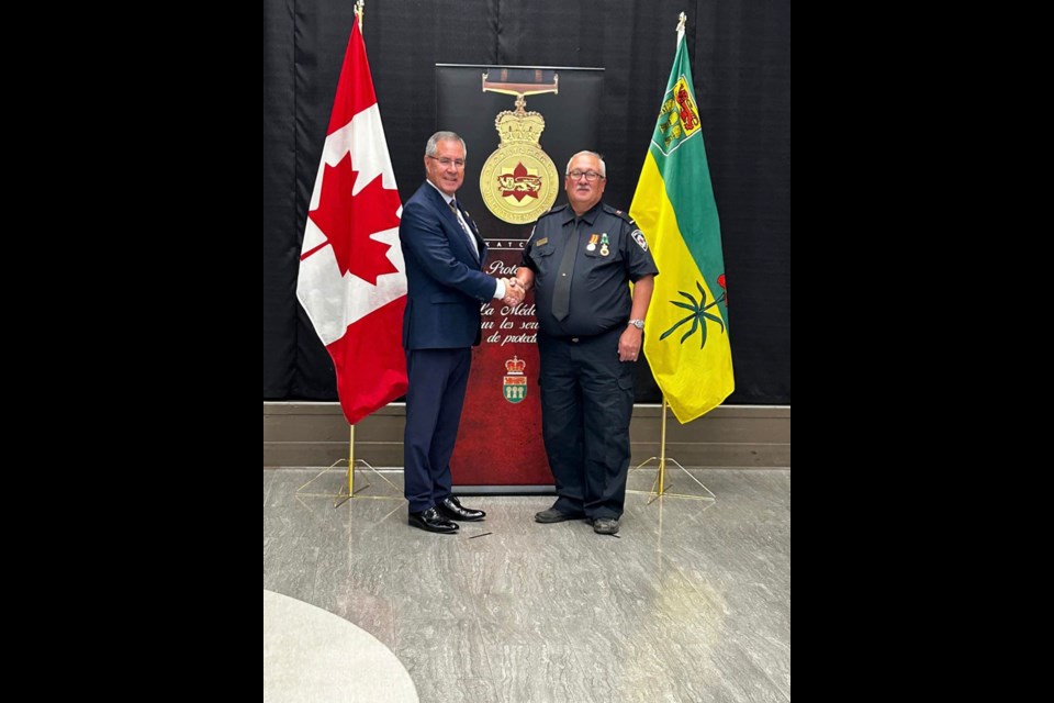 Retired Wilkie firefighter Tom Winterhalt with Saskatchewan Lt.-Gov. Russ Mirasty receiving his 25-year service medal.