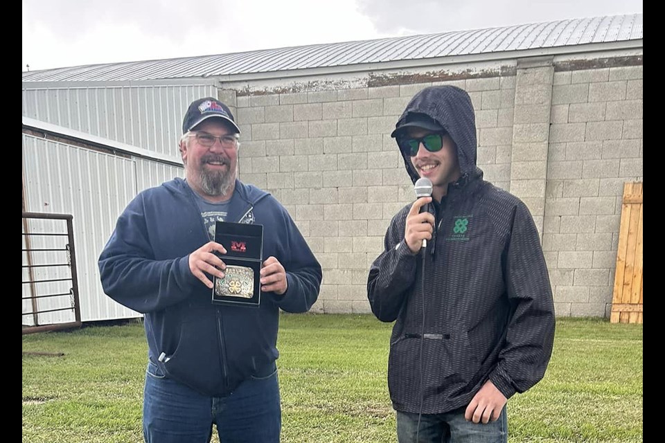 Devan Whitney, president of the Senlac Multiple 4-H Club presented Brady Moncrieff with a buckle for his 25 years of leadership with the club.