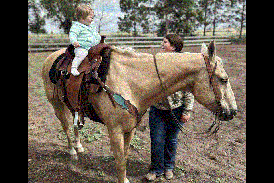 Stella Matthies is one and a half years old, and she loves to sit on her horse Rio, who is 19 years old, while her mom Sheri Matthies stands close by. 