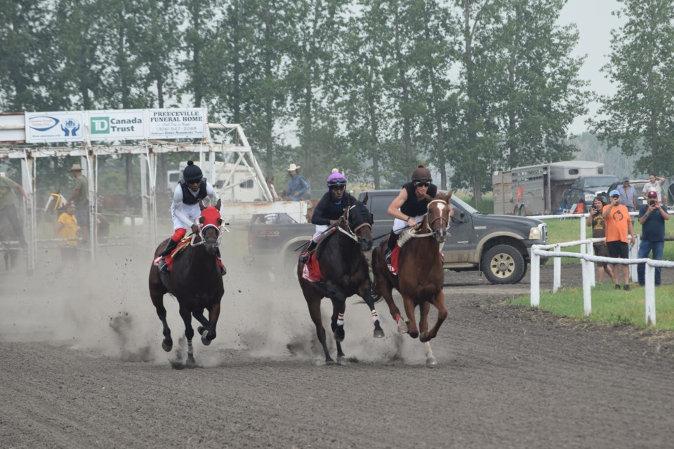 The first horse race started off with dust flying in the air. 