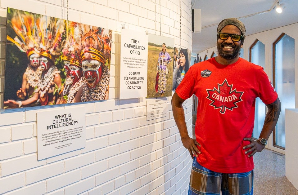 Wilbur Sargunaraj stands in front of the photos in his exhibit highlighting culture awareness.