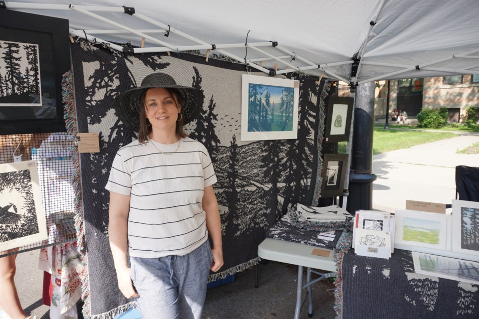 Local artist Amber Bryans poses with her work while on exhibit during the Saskatoon Fringe Festival this summer.