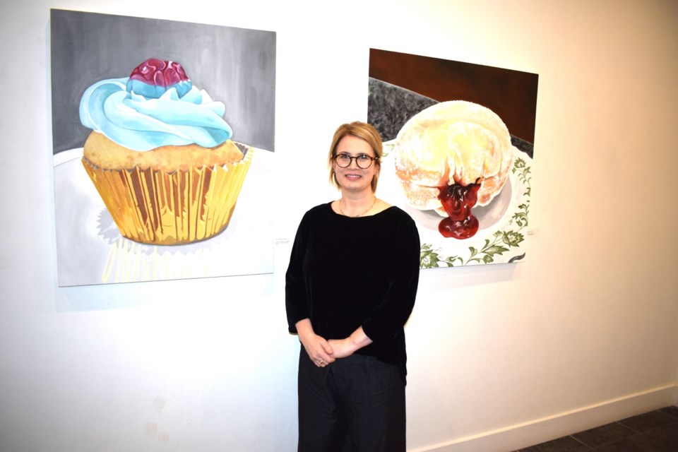 Sarah Cummings Truszkowski with a couple of the paintings in her exhibit. 