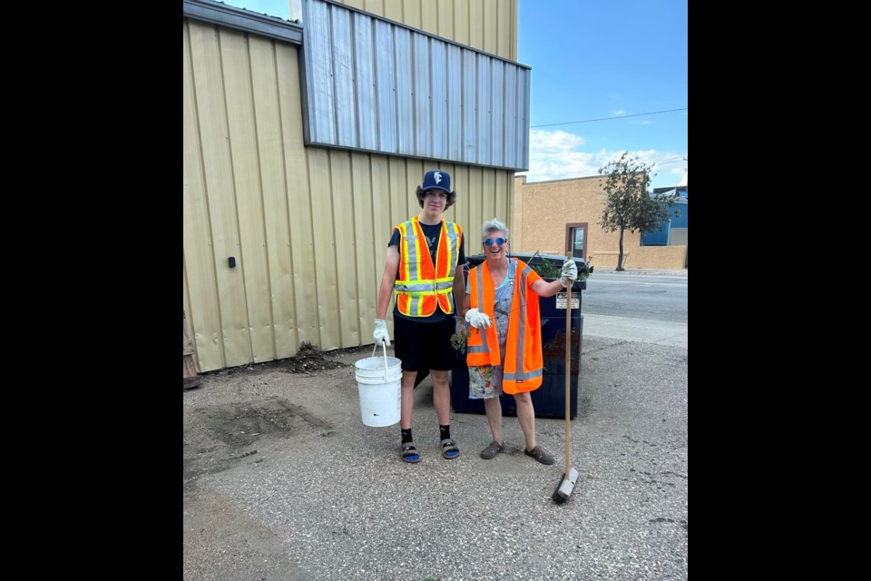 Gale Tytlandsvik, pictured here with Holden Martens, organized a group of volunteers to clean up and beautify the downtown part of Fifth Street.
