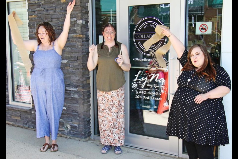 Partners Krystal Browatski, left, and Malia Brackpool celebrated after Coun. Laura Morrissette cut the ribbon for their Collabartive Studio in downtown Weyburn