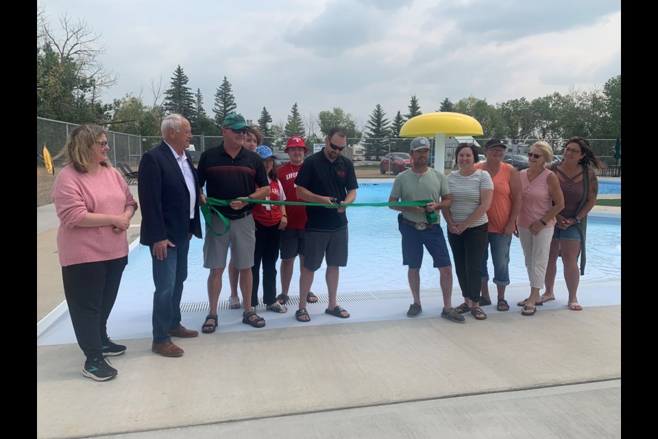 Lisa Moon Harvest, committee member; Minister David Marit; Ted Struthers, Town of Ogema councillor and committee Member; Kyle Leonard, chair Ogema Regional Park Authority and pool rebuild committee chair; Stuart Leonard, Reeve of RM of Key West and committee member; Kara Leonard-Schmidt, Ogema Regional Park Board member and committee member; Lucianne McKague, park board member and committee member; Barb Caird, park board member and committee member; Kassi McCabe, park board member and committee member; and lifeguards in background (from left) Kaden Schmidt, Londyn Leonard and Corin Acton.