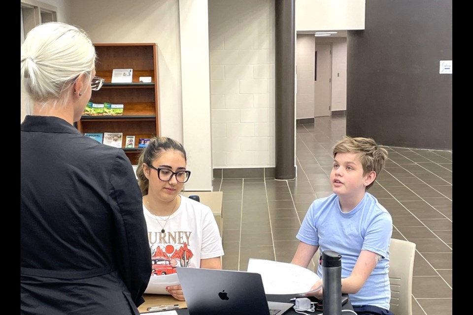 Negin Marashi and Allister Watson, students from the 鶹Ƶeast College's computer science training through projects program, test their software with volunteers from RBC. 
