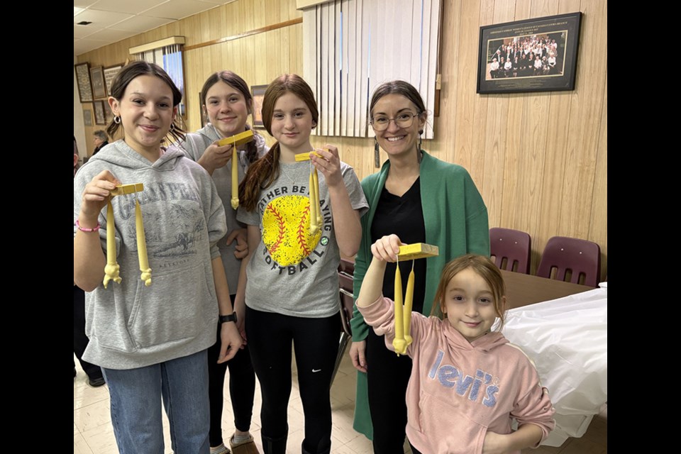 Youth from Canora Catholic and Orthodox churches enthusiastically took part in a candle making workshop on Feb. 3. Showing their finished candles after over an hour of dipping, from left, were:  Mya Dutchak and Maddy Dutchak (Sts. Peter & Paul), and Rachel Mentanko, Lauren Mentanko, and Emily Mentanko (St. Joseph's). 
