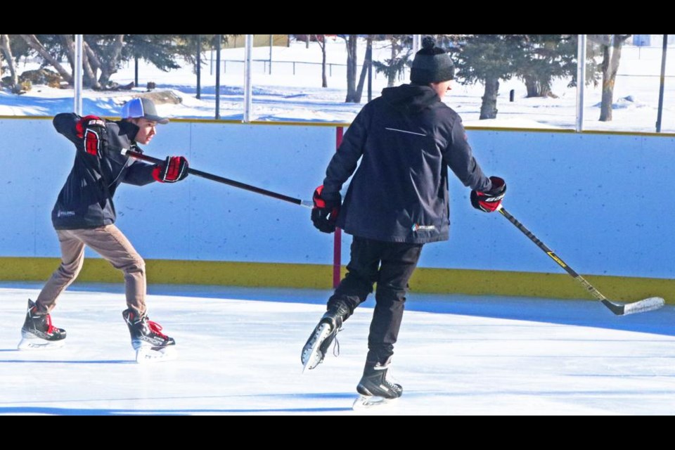 A pair of hockey players took turns shooting on net as they were at the outdoor rink by the Credit Union Spark Centre last winter.