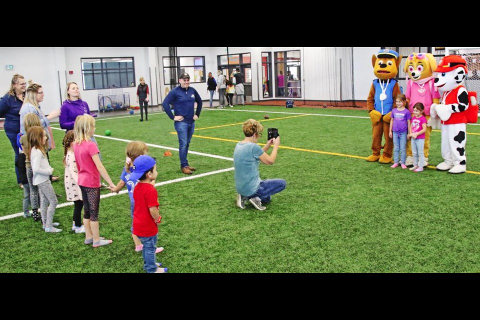 Children lined up to pose with the Paw Patrol, who dropped by Weyburn's CU Spark Centre.