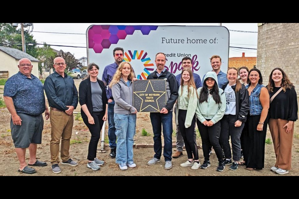 Past and current members of the Weyburn Youth Council gathered with board members of the Weyburn Theatre Co-operative, as they bought the first Star for the Walk of Fame fundraiser for the new Weyburn Cinema. They gathered on the future site of the cinema. In the back row from left are Larry Heggs, Jeff Richards, Laila Bader and Ryan Janke, with former youth mayors Dalton Molnar, Landon Field and Gracyn Knipfel. In front are current Youth Mayor Nikola Erasmus, holding the star with Sean Purdue of the theatre co-operative; youth councillors Harper Williams and Yuan Presto; former youth mayors Jaylynn Haupstein and Megan Ebel, and former youth councillor-secretary Maya Knipfel.