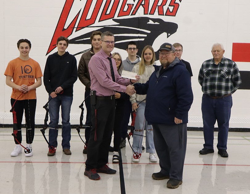 Treasurer Doug Lapitsky and Brad Thompson of the River Ridge Fish & Game League dropped by at Canora Composite School on Feb. 26 to make a donation to the NASP (National Archery in the Schools Program) at CCS and Canora Junior Elementary School to fund the trip to NASP provincials in Shaunavon on April 12-13. From left, were: (back row) archers Jackson Palagian, Chase Curtis, Ferlyn Brass, Teagan Jones, Jacob Lowes and Brad Thompson (River Ridge); (middle) Merrick Derkatch and Natalie Kosar; and (front) CCS Archery Coach Thomas Lowes accepted at donation of $4,305 from River Ridge Fish & Game League Treasurer Doug Lapitsky.