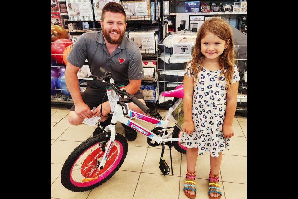 Brendan Burns of Canadian Tire presented a new bike to Chloe P., which she won through the Weyburn bike rodeo on July 3.