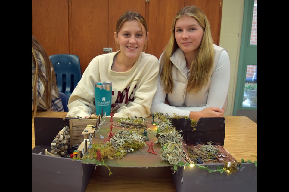 Makayla Heshka, left, and Sofia Tratch worked together to create their First World War trench warfare diorama, which included considerable research on where to position the soldiers. The red soldiers are Germans, the Russians are silver, and the British and French soldiers are painted green.