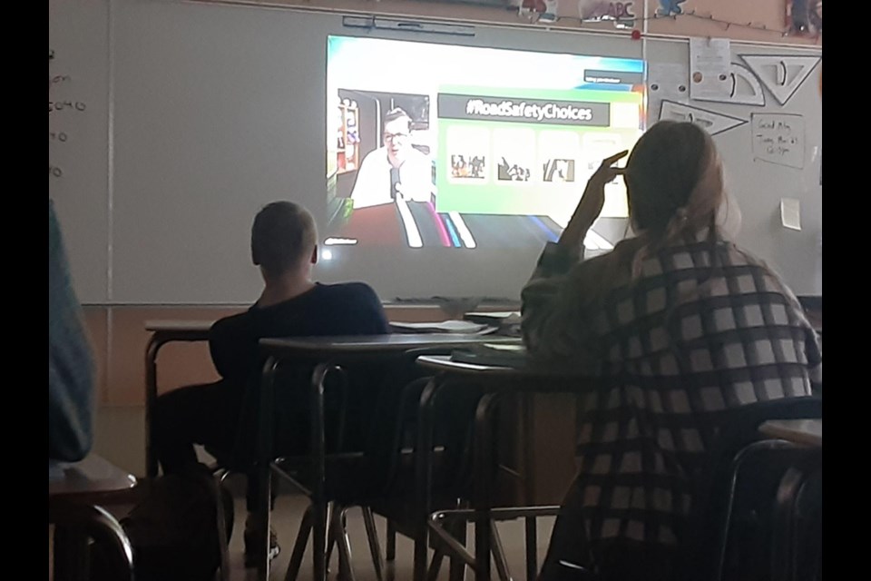 John Westhavor, the sole survivor of a horrific highway crash in New Brunswick, spoke to students about the consequences of dangerous driving. From left are Jaxon Bisshop, and Shayna Leson. Westhavor was on the screen.