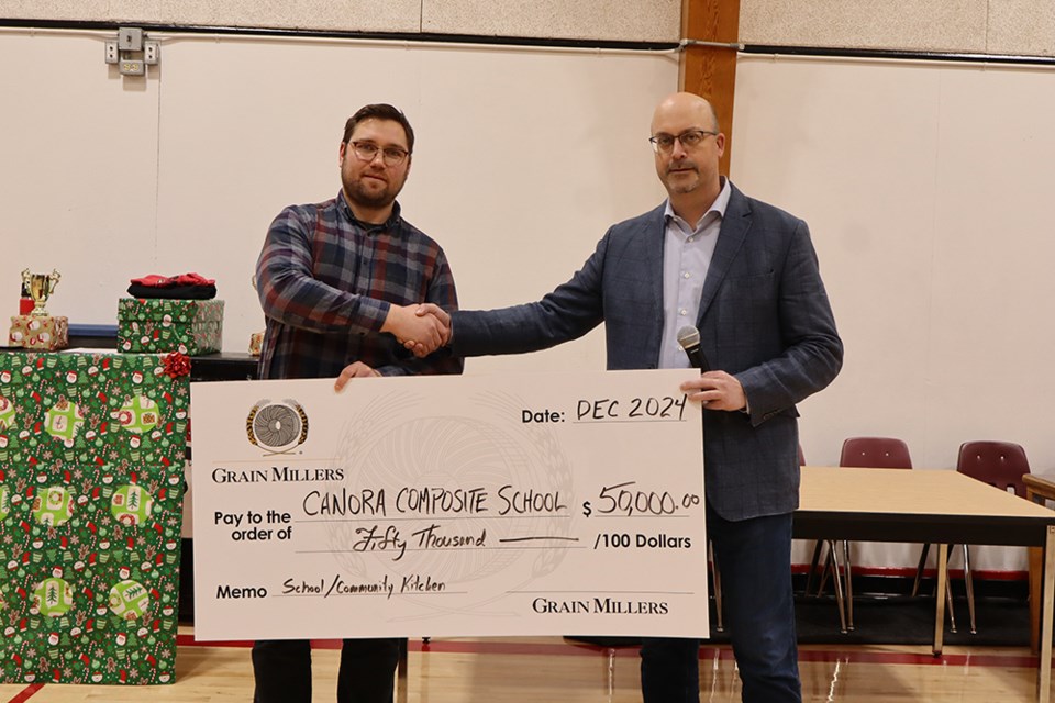 On Dec. 20 at the Christmas assembly, Grain Millers of Yorkton, represented by Terry Tyson (right), made a cheque presentation of $50,000 to the Canora Composite School nutrition program. Accepting the donation was CCS Principal Derek Serdachny. 