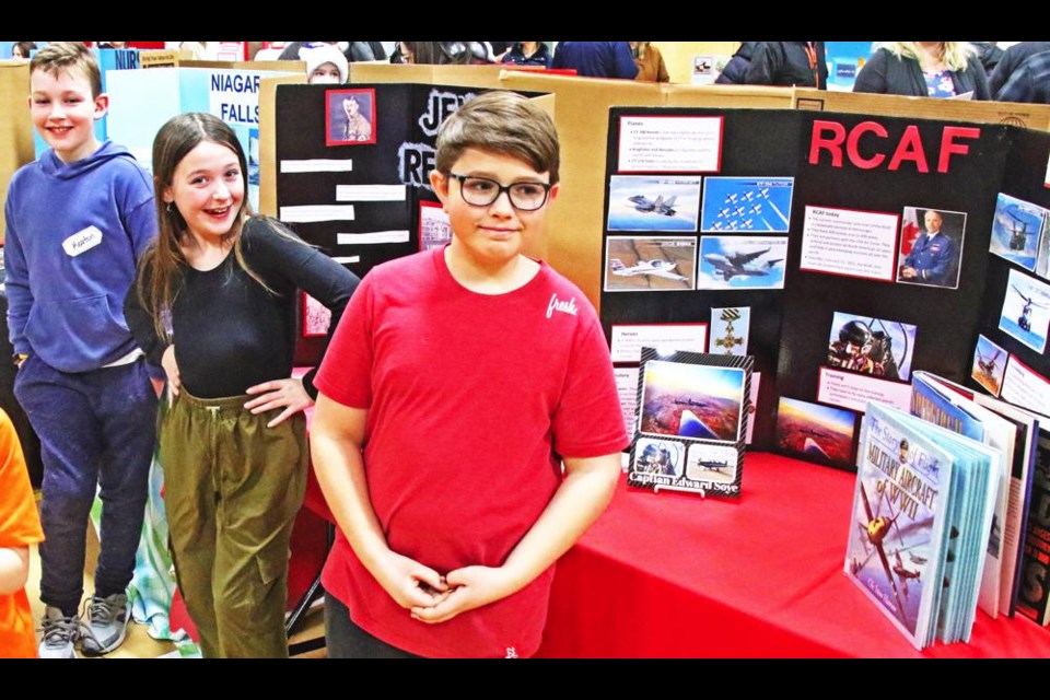 Grade 5 students showed off their Heritage Fair projects at APES on Thursday. From left are Keaton Walcer, whose project was on Niagara Falls; Olivia McKinnon, who did a project on Jewish refugees in Canada; and Nixon Pearce, whose project was on the Royal Canadian Air Force.