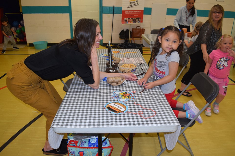 April Wapash looked like she was enjoying the making a bird feeder station at the IMPACT Early Childhood Fair at CJES on May 29, which offered fun ways to prepare three-to-five year olds for starting school. With April was Susan Robertson, the Good Spirit School Division Early Years Consultant.