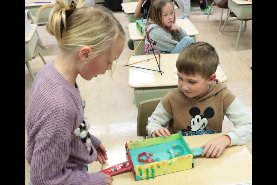 Grade 3 student Jake showed Violet his magnetism project, which was done as part of a science unit at St. Michael School.