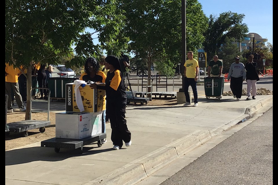 Volunteers help newly-arrived University of Regina students move into the campus apartments.