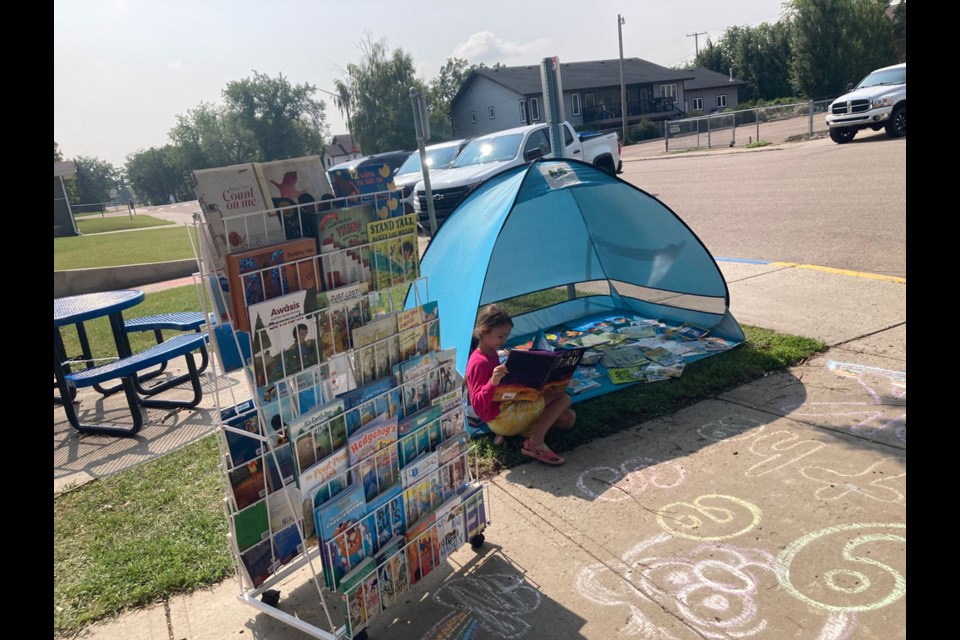 Philomena Ogrodnick enjoyed some shade while reading a book she selected at the Pages in the Park pop-up activity at St. Peter's School July 19.