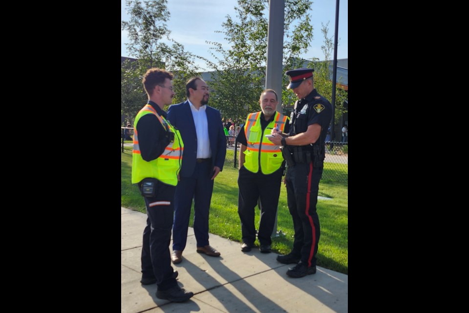 City Parking Services Manager Wayne Sum, second left, and Saskatoon Police Service Sgt. Ken Kane, right, oversee the traffic situation around Chief Whitecap School and St. Kateri Tekakwitha Catholic School on Tuesday, Sept. 3.