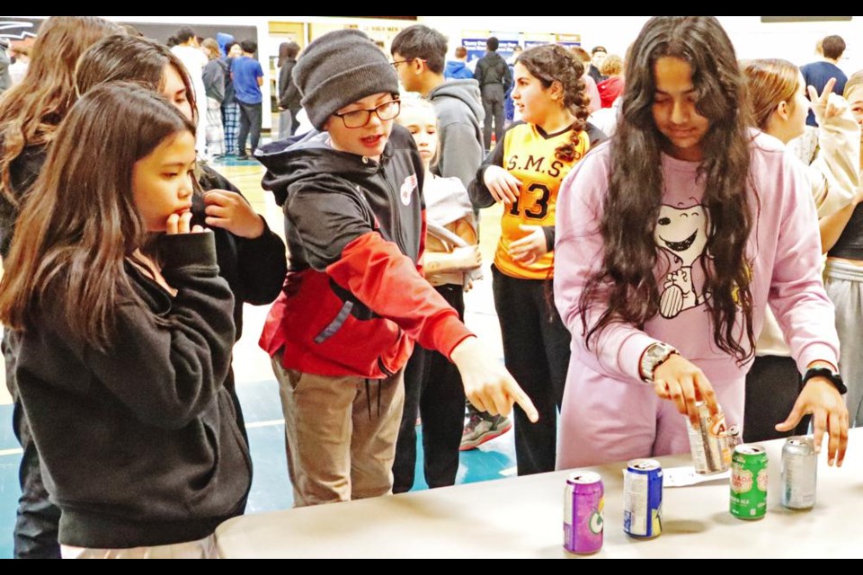 Students had to work as a team to rearrange this line of pop cans, in a 'minute-to-win-it' race.