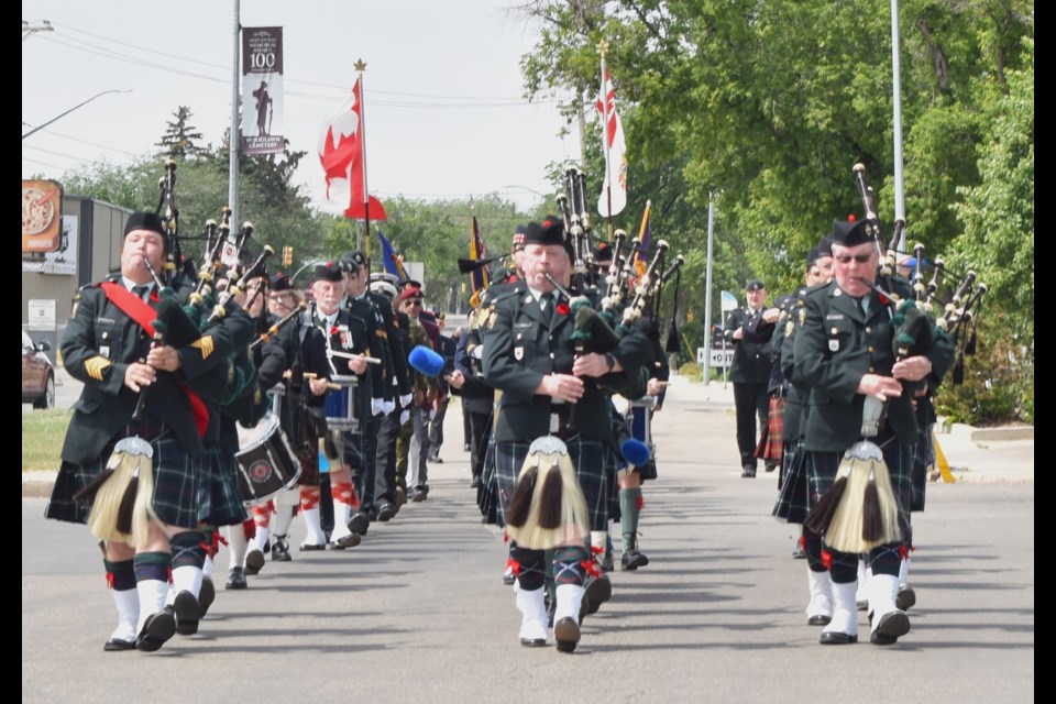 The North Saskatchewan Regiment Pipes and Drums lead the parade entering the Next-of-Kin Memorial Avenue Gate at Woodlawn Cemetery. 