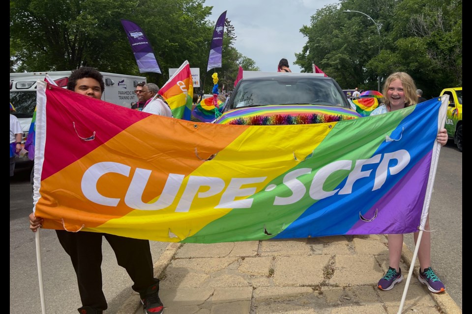 Representatives of the Canadian Union of Public Employees in Saskatchewan hold their banner during the Pride Festival in Saskatoon on Saturday, June 17.