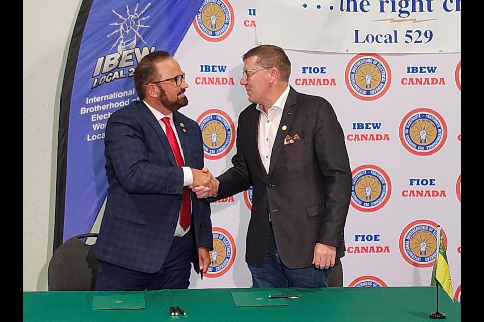 Premier Scott Moe, right, and International Brotherhood of Electrical Workers First District International Vice President Russ Shewchuck shake hands after sealing the apprentice and training partnership on Thursday, Sept. 19, at the IBEW office in the city.