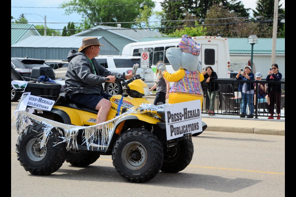 John Gottschalk drives the Press-Herald entry in the parade, helping distribute fresh copies of the latest paper to those along the parade route.