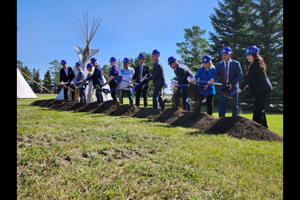 Premier Scott Moe, ninth left, and Saskatchewan Polytechnic President Dr. Larry Rosia, seventh left, lead the ceremonial shovelling of dirt.