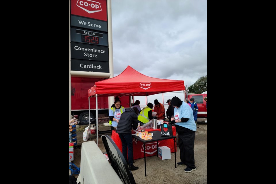 Delta Co-op staff keep warm during a barbecue they hosted as part of their Fuel Good Day initiative in September.