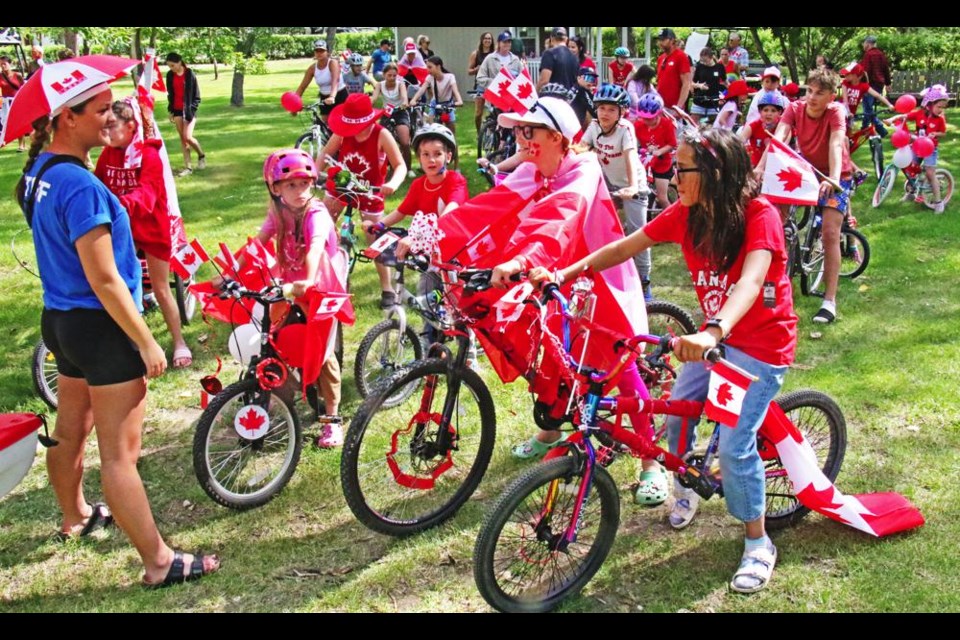 Park staff Dayton Kopec, at left, helped organize the children for the bike parade to kick off Canada Day at Nickle Lake Regional Park on Monday.