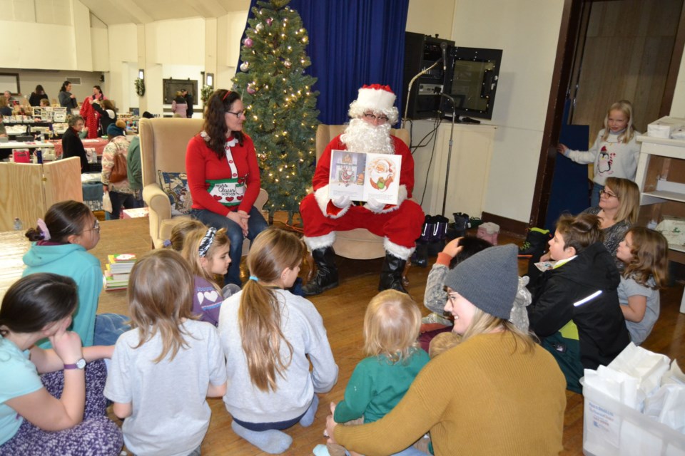 Santa Claus made a brief visit to read a few books during the Christmas craft sale. Karolyn Kosheluk, left, helped Santa pick out a book.