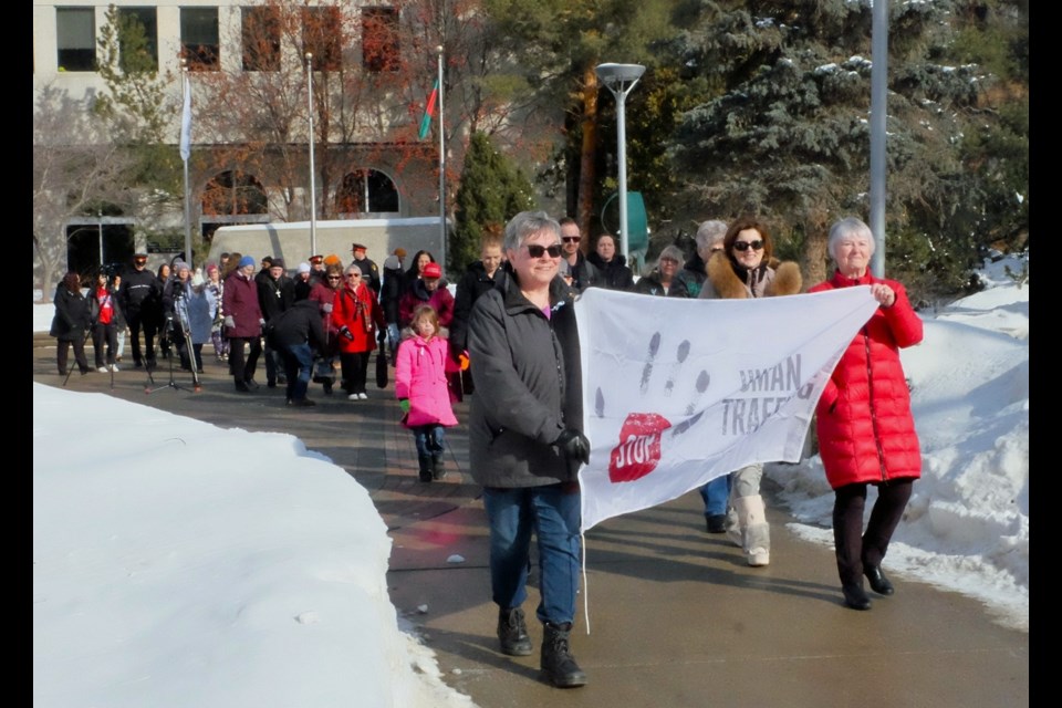 Anne Ashcroft, left, and Donna Aldous from the Catholic Women’s League St. Anne's Parish Council hold the Anti-Human Trafficking banner to lead the group in their walk. 