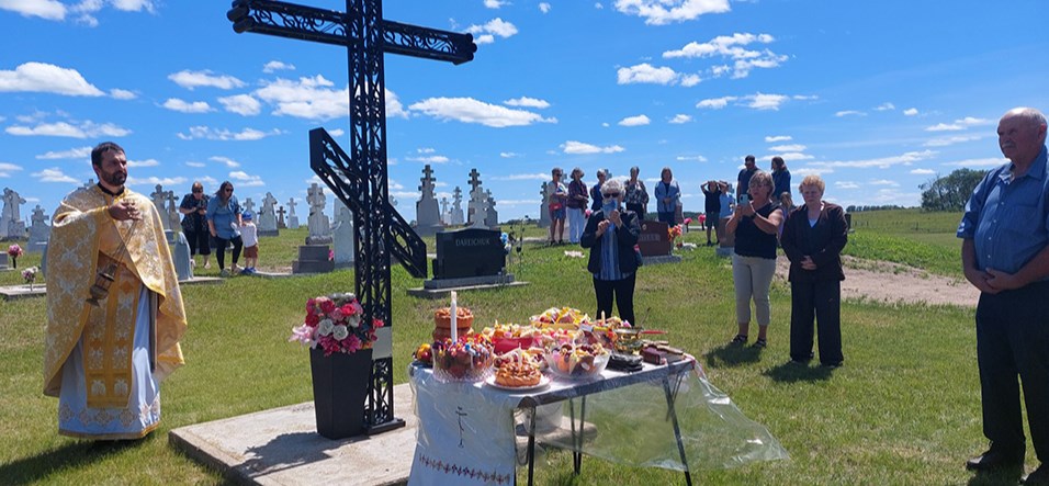 At the cemetery, three braided kolachi and a variety of bowls of fruit and sweet treats were placed on the crucify platform and blessed. Fr. Obukh with cantor Zenovia Zuch, altar server Kevin Stewart and cross bearers Michael Makowski and Orville Drobot blessed each individual grave in the cemetery, with the congregantion singing the traditional Orthodox Lament Vichnaya Pamyat (Eternal Memory).