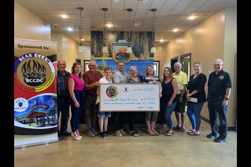 Directors of the Bear Claw Community Development Corporation – Jack Wilson from the RM of Moose Mountain and Wayne Orsted from the Town of Carlyle – presented cheques totaling $31,995 to organizations within the area on June 23. Participating in the photo are Wilson, Danielle Steele with the Town of Carlyle, Wayne Wilson of Sutherland Cemetery, Genie Geiger with Friends of Moose Mountain Lodge, Rob Klassen of the Carlyle Fire Department, Dolores Young with the Dickens Village Festival, Darlene Burnett of the Carlyle & District Food Bank, Karen Fischer from Cannington Lake, Ron Paul with the museum, Christie Hislop from the RM/Cannington Lake, and Orsted. 