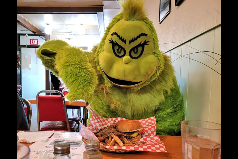 The Grinch visited downtown North Battleford Saturday. Here he is enjoying lunch. 