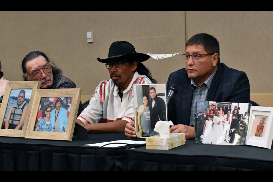 Mark Arcand, right, holds a photo of his sister Bonnie, who was among the 10 persons who were killed in a brutal stabbing attack on Sunday, Sept. 4, at the James Smith Cree Nation. Others in the photo are Shawn Burns, left, and his son Brian Burns, who is Bonnie's husband.