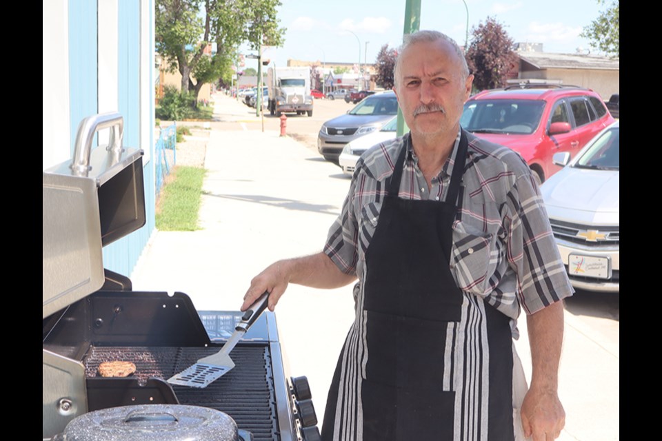 Charlie Rudachyk is an old pro on the barbecue and was flipping burgers for the Keen Age Centre Lunch and Garage Sale on July 13 and 14.