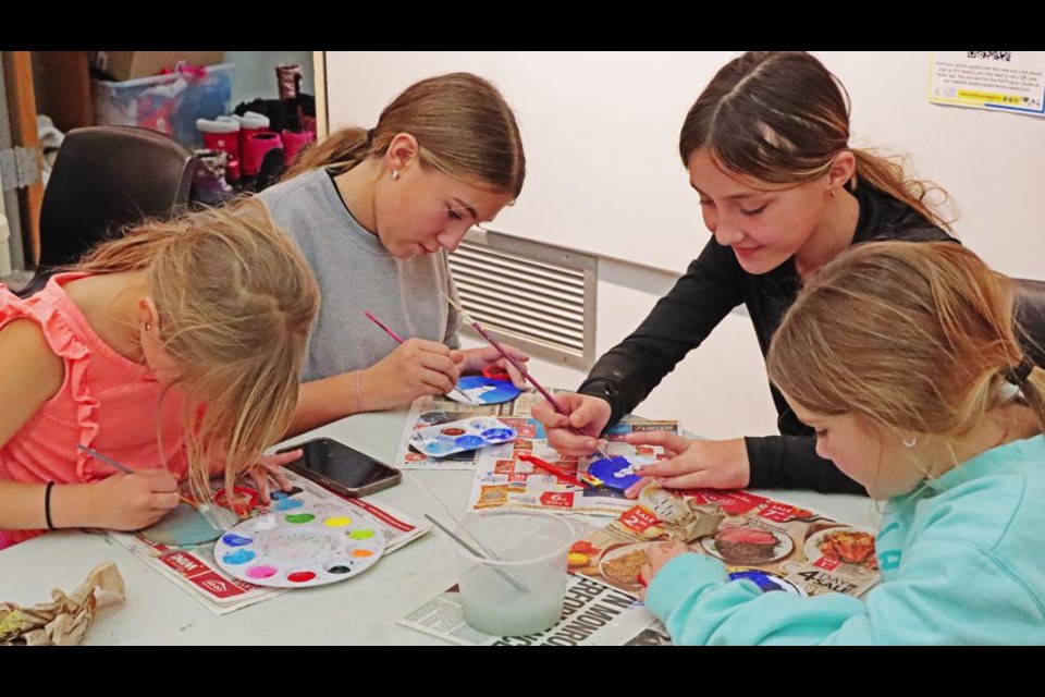 Sisters Olivia, Sophie, Christina and Lyla worked on making Christmas ornaments at a craft station, during Jingles and Mingles on Thursday at the Weyburn Public Library.