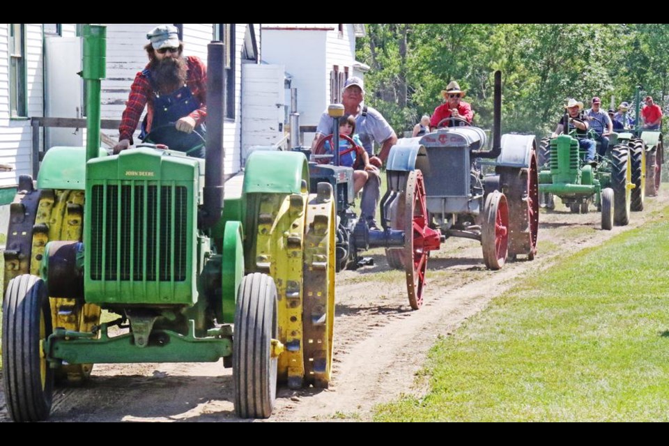 Lyle Stomp of Fillmore led this line of antique tractors through Midale's heritage village in 2022.