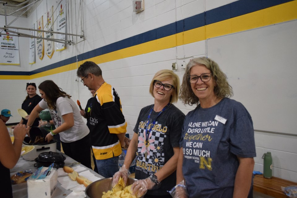 From right to left, Norquay School principal Audrey Severson and vice principal Stacey Rubletz were part of the line of teachers and staff preparing and handing out the various burgers, hotdogs, potato chips, and more available at the schools new school year barbecue.