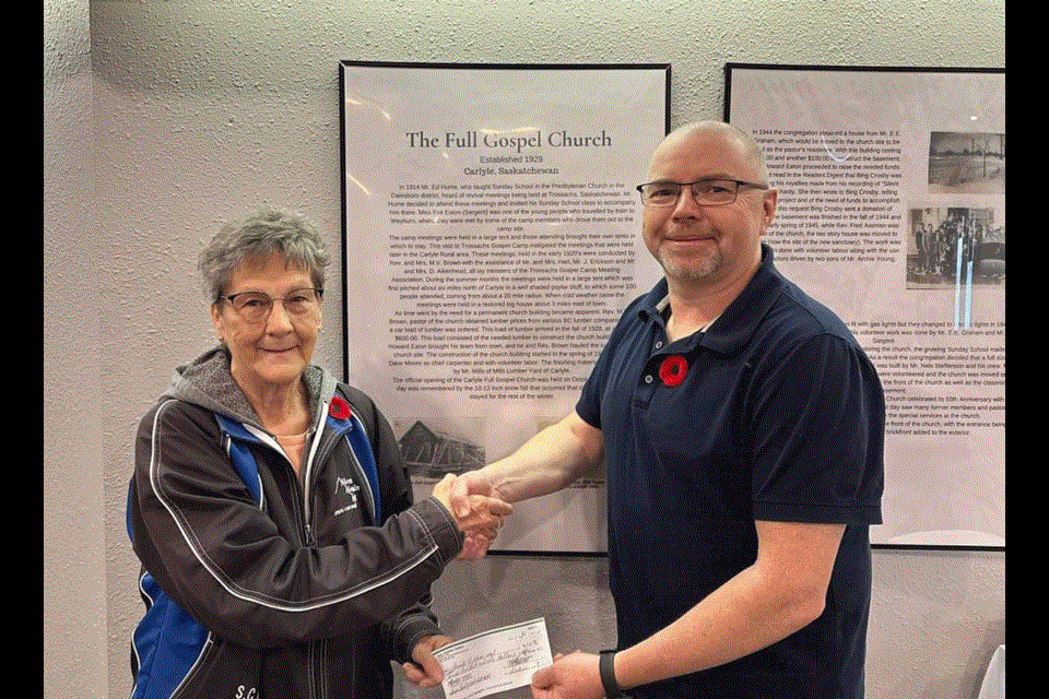 CARLYLE - The Carlyle Full Gospel Church donated the proceeds from its October lunch program to the Friends of Moose Mountain Lodge. President Jenny Geiger-Martel accepts a cheque for $260 from Carlyle Full Gospel Church pastor Rodney Cox.