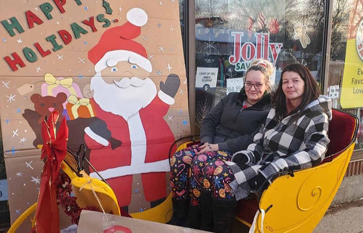 Karleen Rubletz (left) and Gloria Pierrard, Red Apple staff, enjoyed their perch in the sleigh for Fill the Sleigh Day on Dec. 7 at the Canora Red Apple Store.