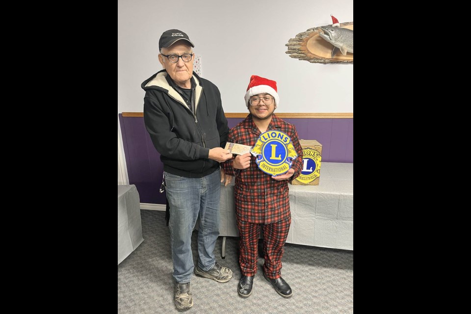 Stoughton Lions Club president Ed Young presents Kirscen Rulloda with a cheque when he won the 50/50 draw. 