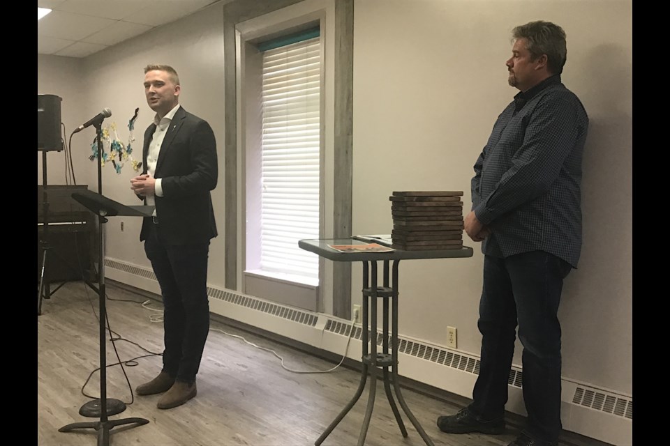 Battlefords MLA Jeremy Cockrill speaks at Territorial Youth Services campaign launch with Perry Neufeld looking on.