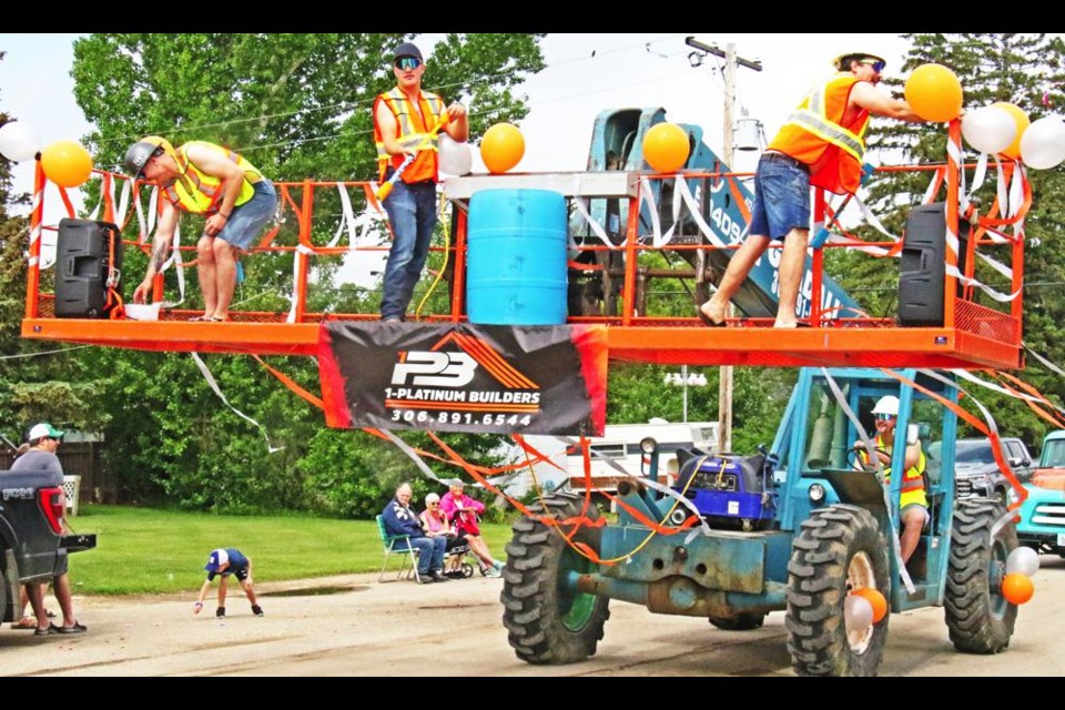 A crew rode on a scaffold carried by a Gradeall, in the Yellow Grass parade on Saturday to mark the summer solstice.